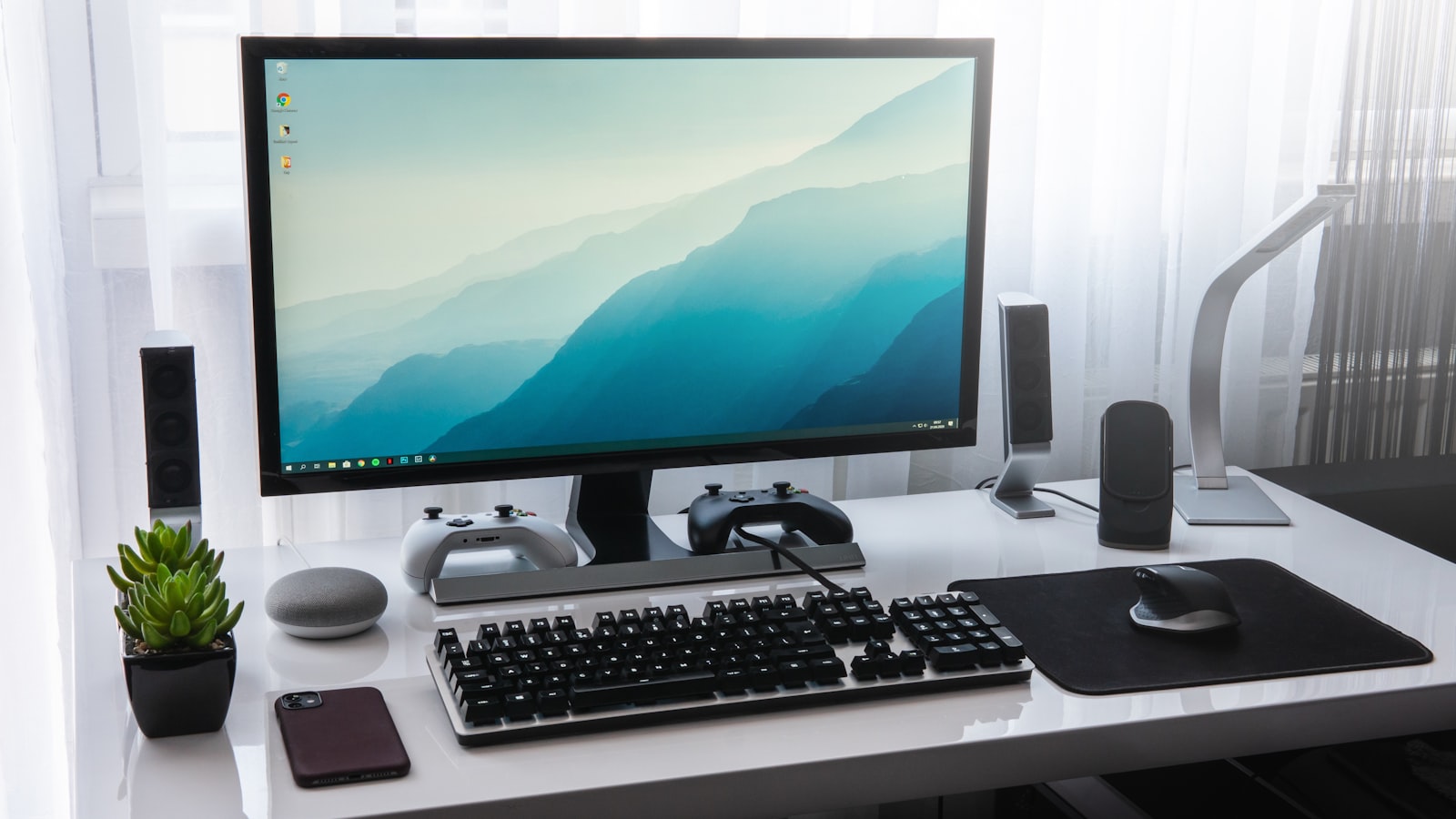 Google Home Speaker am PC: Was der Gemini-Lautsprecher am Schreibtisch taugt Ein aufgeräumter Schreibtisch mit Monitor, Tastatur und Controllern