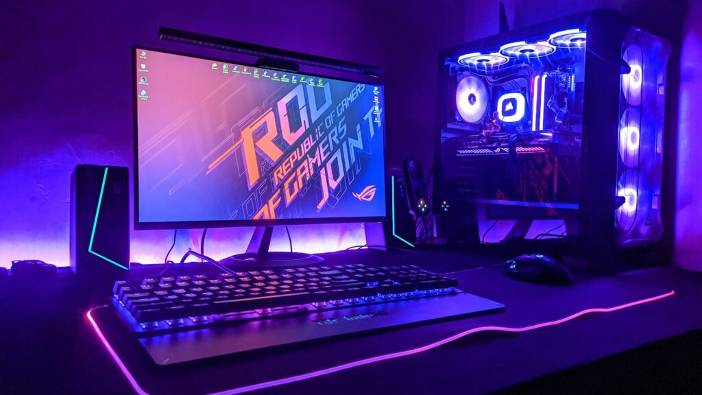 ASUS ROG Gjallar am PC: Was die Gaming-Soundbar am Schreibtisch taugt Beleuchteter Gaming-Schreibtisch mit Monitor, Tastatur und Rechner in violettem Licht