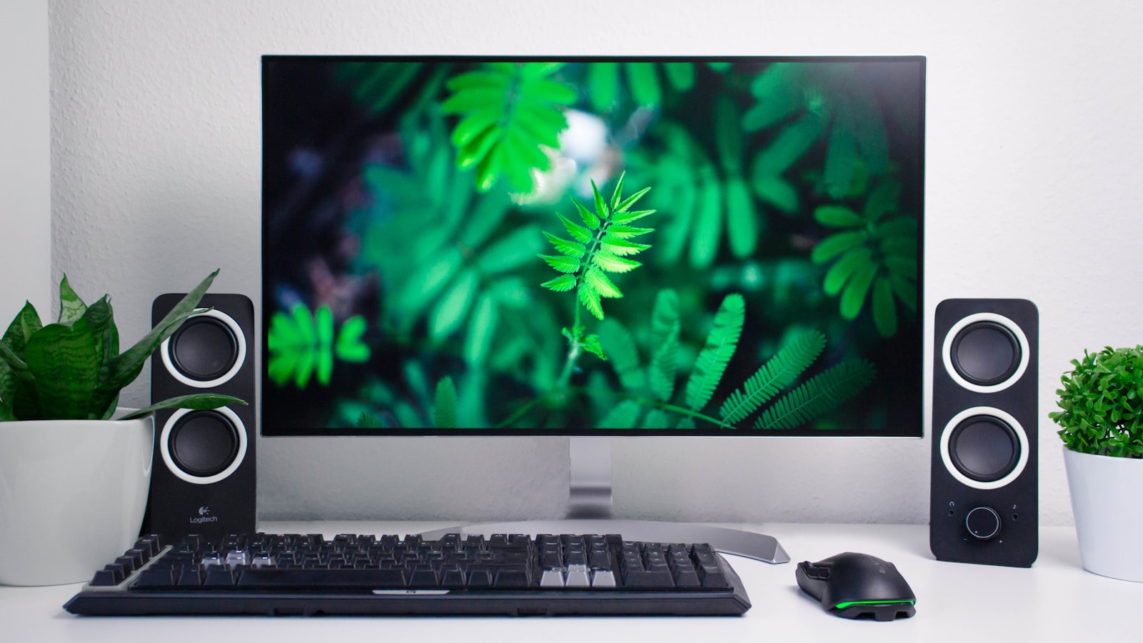 Zwei Lautsprecher links und rechts eines Monitors auf einem Schreibtisch